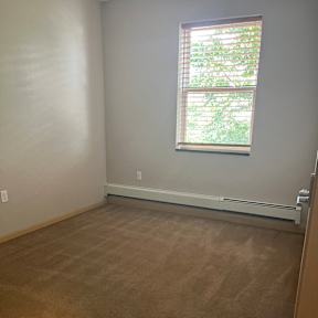 A room with a window and a wall with a textured surface.