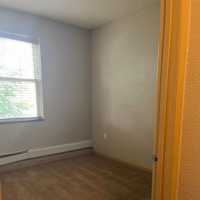 A room with a window and a ceiling fan.