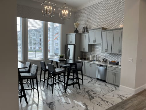 a kitchen with gray cabinets and a marble floor