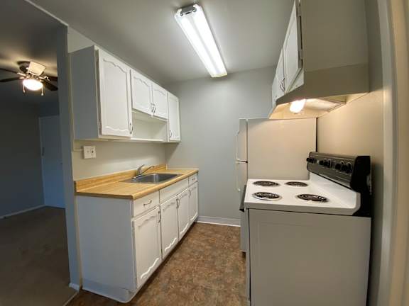 a kitchen with white cabinets and a white stove top oven