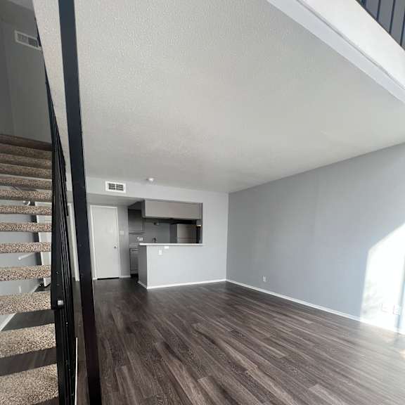 A staircase with a wooden handrail and a carpeted runner.