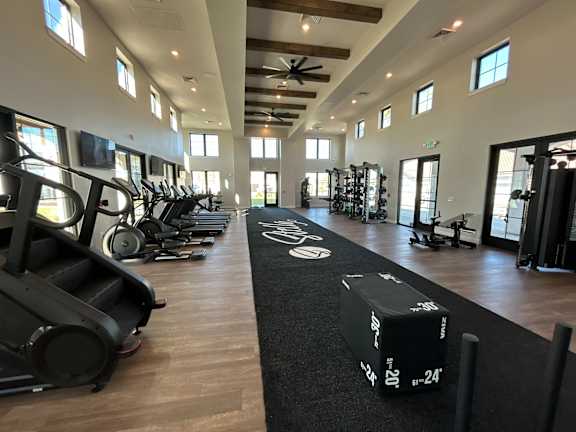 A gym with treadmills, elliptical machines, and other exercise equipment.