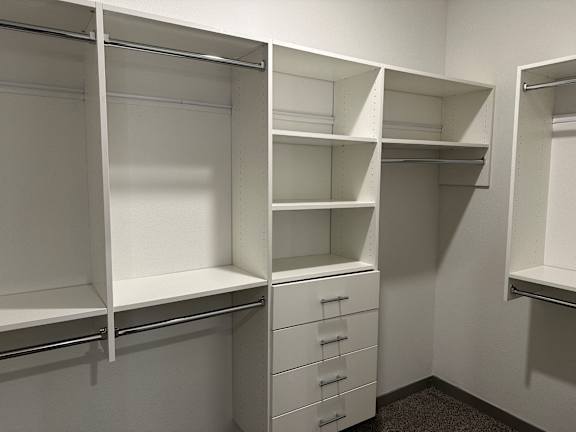 a walk in closet with shelves and drawers and at The Depot Luxury Apartment Homes, Raymore, MO, 64083