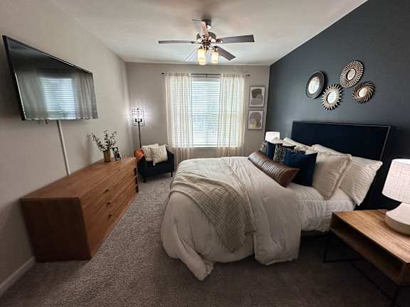 a bedroom with a large bed and a ceiling fan at Watermark at Steele Crossing, Arkansas