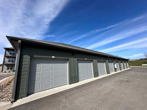 a garage with a row of garage doors and a blue sky  at The Depot Luxury Apartment Homes, Raymore, 64083