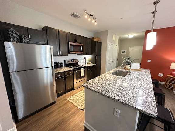 a kitchen with stainless steel appliances and granite counter tops at Watermark at Steele Crossing, Arkansas, 72703