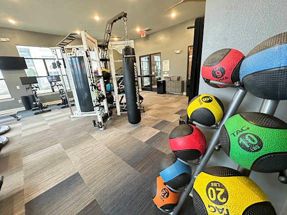 a gym with weights and a punching bag on a rack at Watermark at Steele Crossing, Arkansas