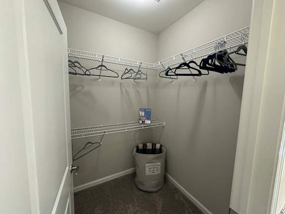 a walk in closet with a trash can and hanging racks at Watermark at Steele Crossing, Fayetteville, AR