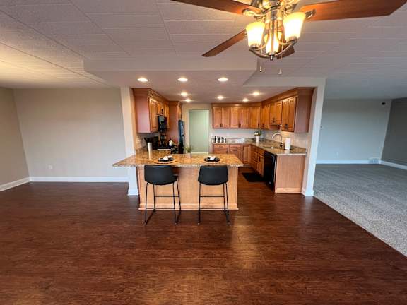 A kitchen with wooden cabinets and a ceiling fan.