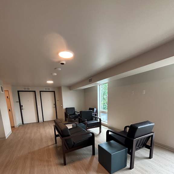 A wall-mounted speaker system is installed in a room with wooden walls.