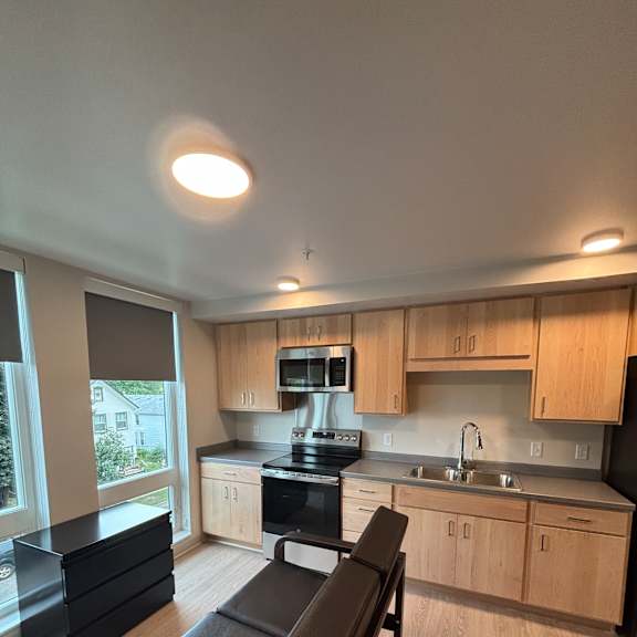 A modern kitchen with a window overlooking a garden.