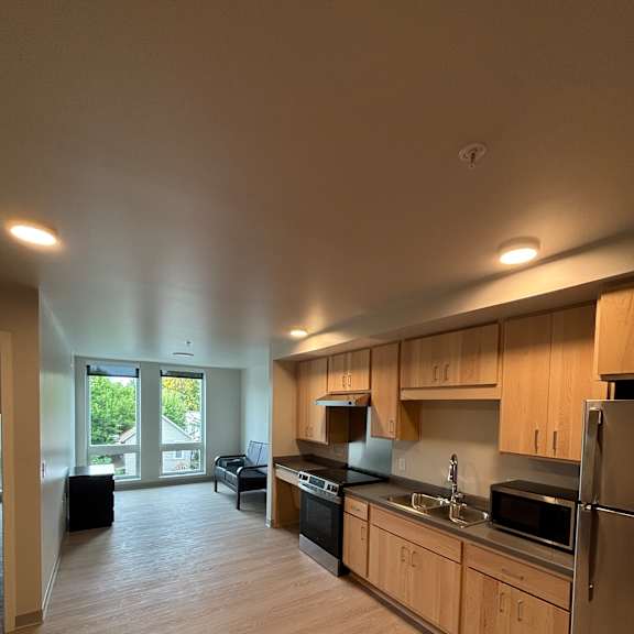 A view of a room with a window and a ceiling fan.