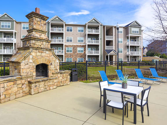 A patio with a table and chairs in front of a building.