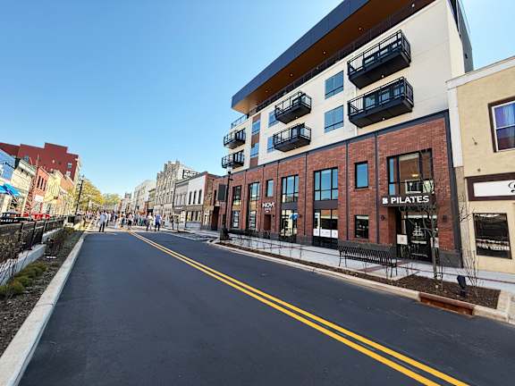 A street view with a building that has a sign that says "PILATES".