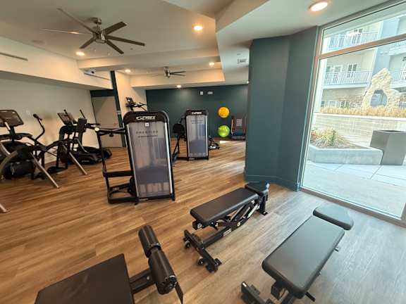 A gym with a variety of equipment including treadmills, weights, and exercise machines.