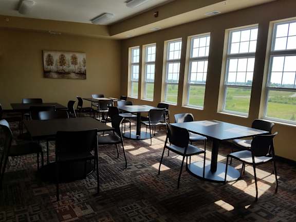 a dining room with tables and chairs and windows