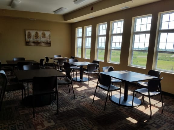 a dining room with tables and chairs and windows
