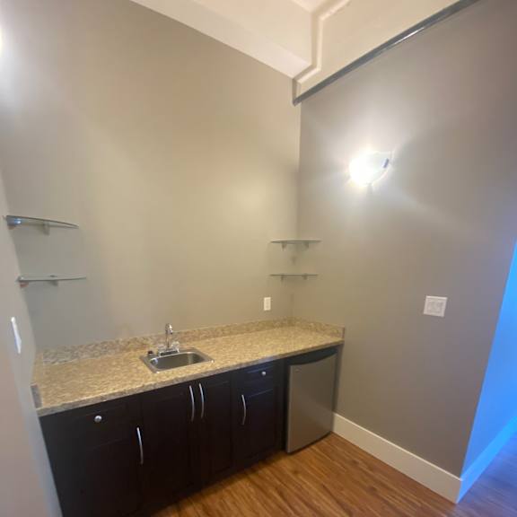 A nook with a wooden wall, cabinets and a dishwasher.
