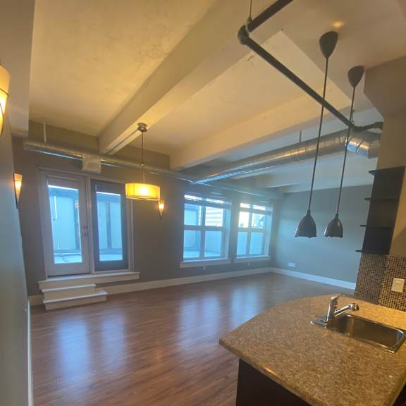 A large island overlooking a well lit living room.