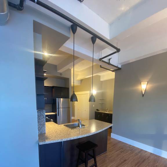 A full kitchen with drop lighting above the island.