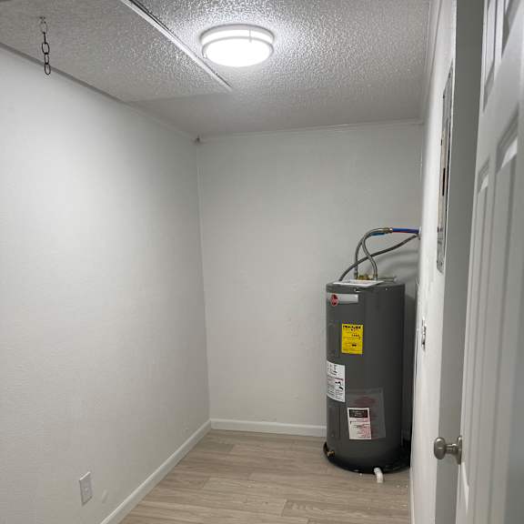 A small, white, enclosed space with a vent on the wall.