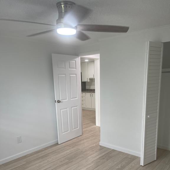 A white ceiling fan with a light on it.