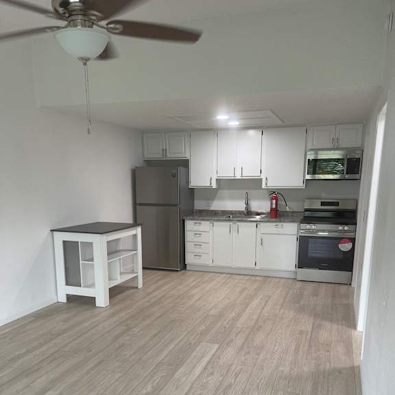 A kitchen with a wooden wall and white appliances.