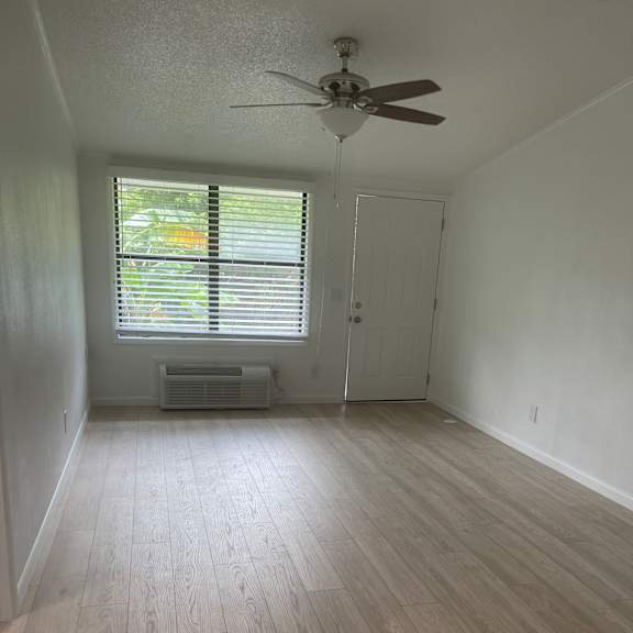 A room with wooden flooring and a ceiling fan.