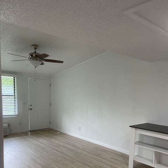 A ceiling fan hangs from the ceiling in a room with wooden walls.