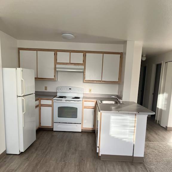 A modern kitchen with a white fridge and microwave.