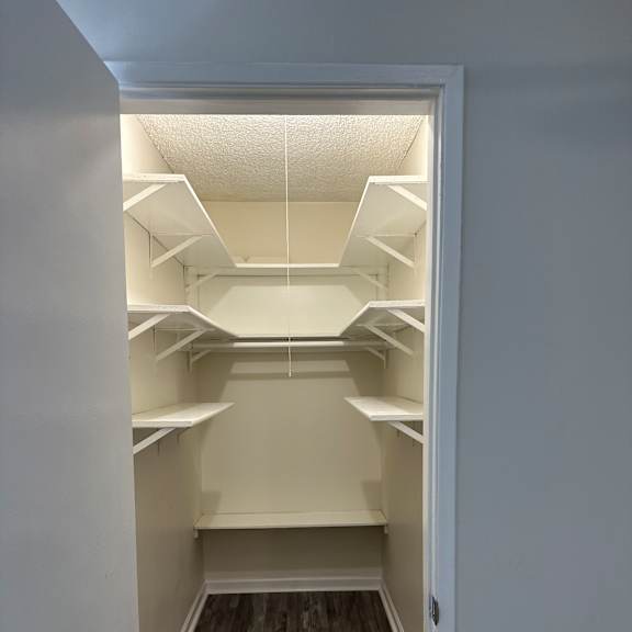 A white interior space with a stone wall and a white ceiling.