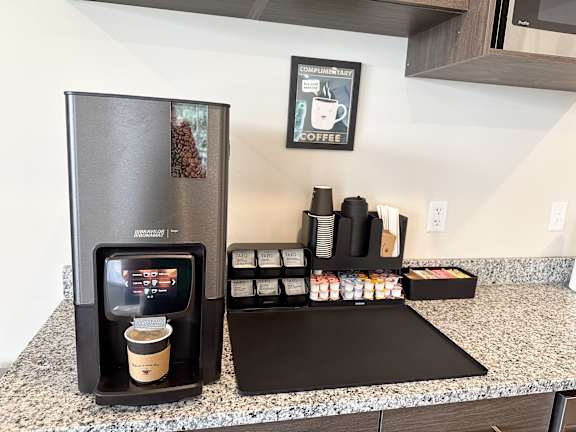 A coffee machine is on a counter with a coffee cup in it.