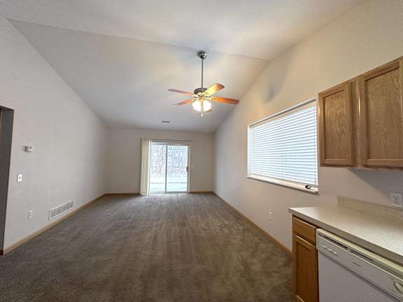 A room with a ceiling fan and a window with blinds.