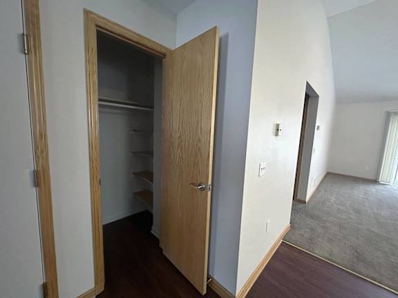 A wooden door with a shelf underneath it is open.