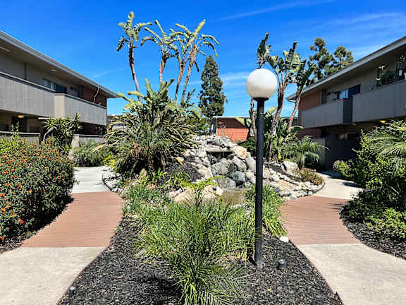 a courtyard with plants and a lamp post