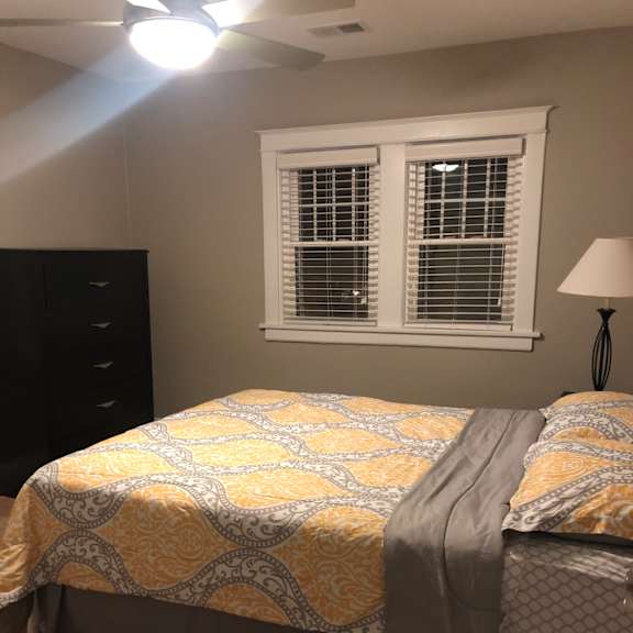 a bunk bed with a yellow and gray quilt and a window