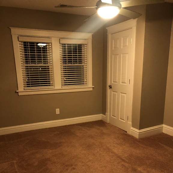 a room with a window with a cage in it and a light on the ceiling