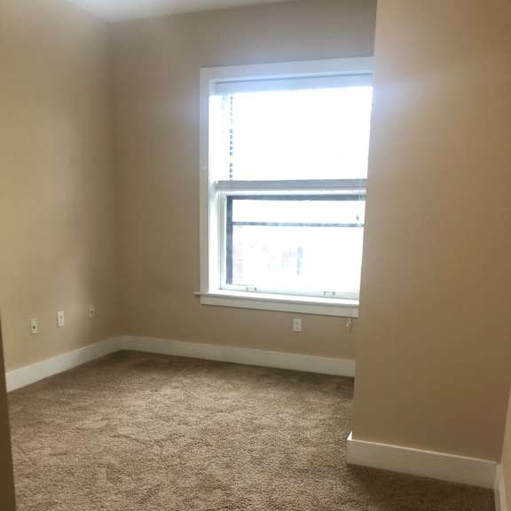 a room with a window on the wall and a staircase
