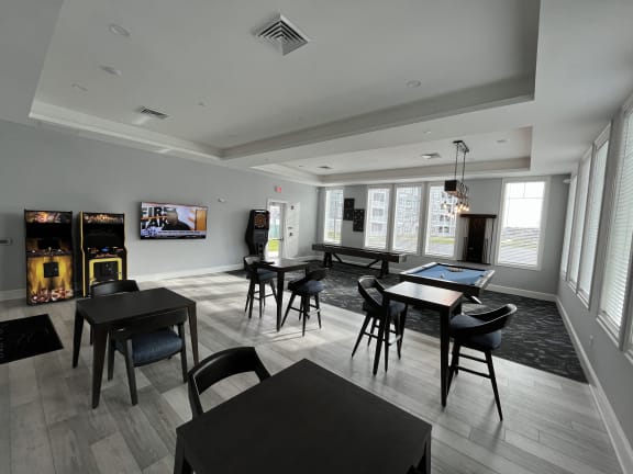 a large room with tables and chairs and a flat screen tv on the wall at The Oasis at Plymouth, Massachusetts