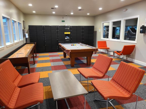 a game room with a pool table and chairs