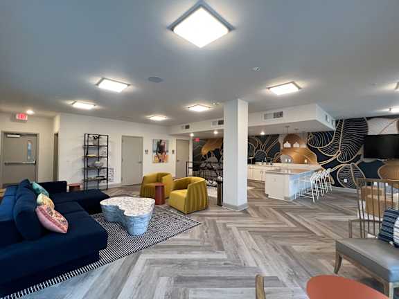 A spacious room with a variety of seating options and a patterned carpet.
