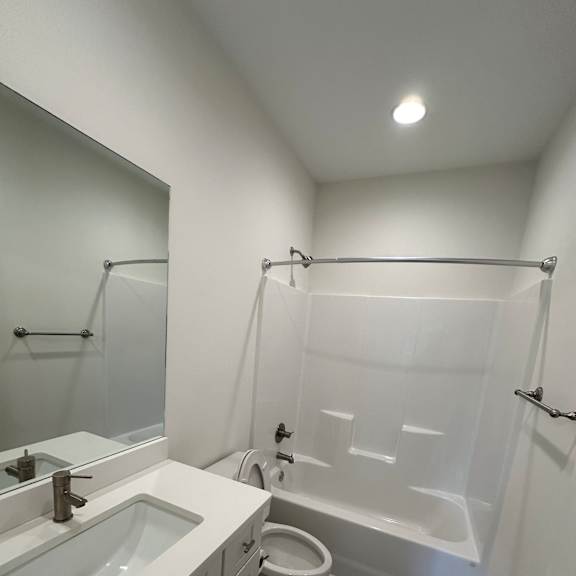 A modern bathroom with a glass shower enclosure and a white bathtub.