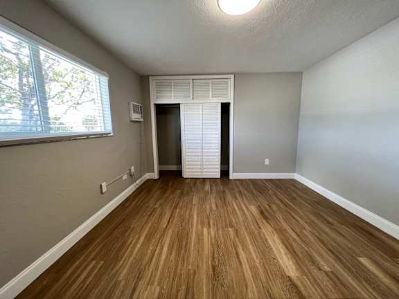 an empty living room with wooden floors and a window  at Palm Gardens @ Biscayne Gardens, North Miami, FL, 33181