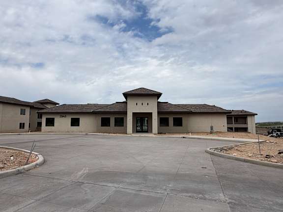 A large building with a parking lot in front.