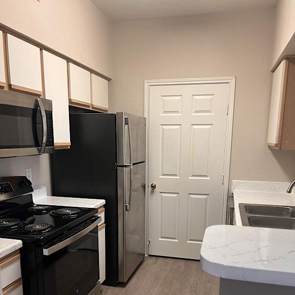 a small kitchen with a stove and a door