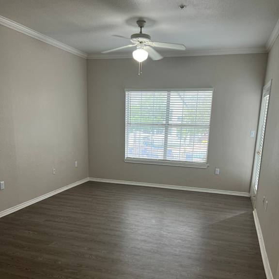 an empty room with a window and a wooden wall