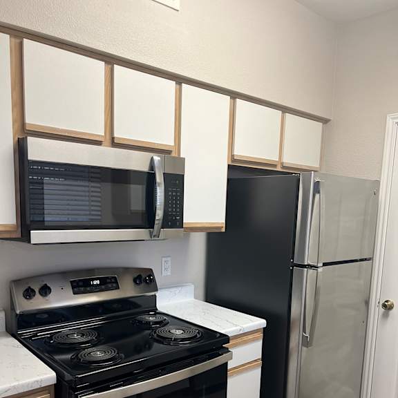 a kitchen with a stove and a microwave and some drawers