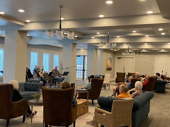 a group of people sitting in a living room with chairs and a band playing music at LIV at Boerne Hills an Active Senior Community 62+, Boerne, TX, 78006