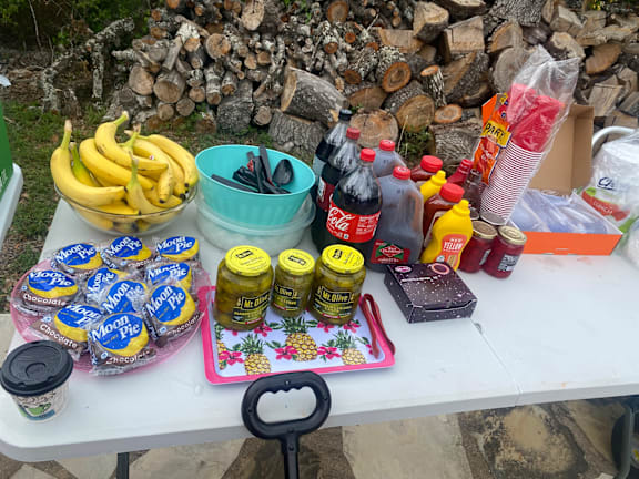 a table with various food items on it and a pile of wood at LIV at Boerne Hills an Active Senior Community 62+, Boerne, TX, 78006