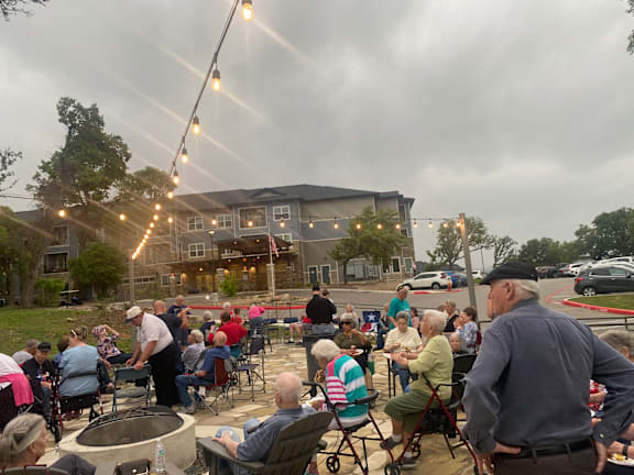 a crowd of people sitting at tables outside of a building at LIV at Boerne Hills an Active Senior Community 62+, Boerne, TX, 78006